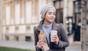 person holding coffee and pastry
